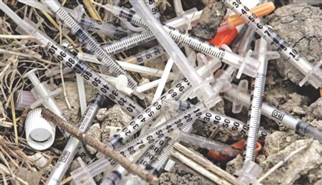 Discarded syringes illustrating sharps hazards during drug den clearance in Belfast