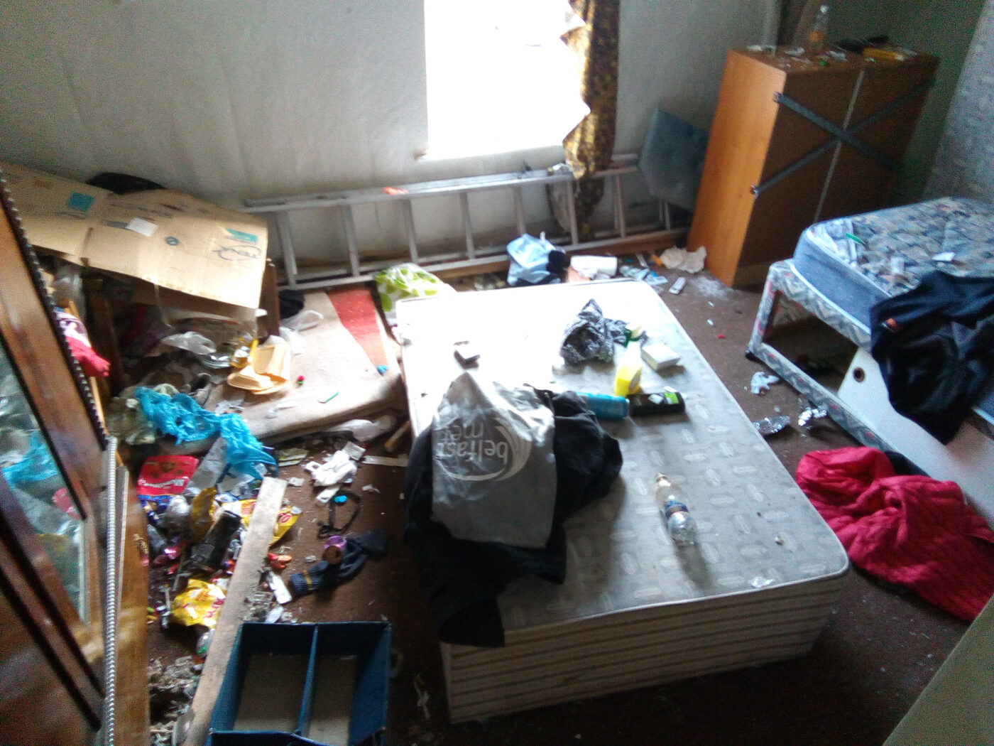 Severely cluttered room requiring gross filth cleanup in Ballymena