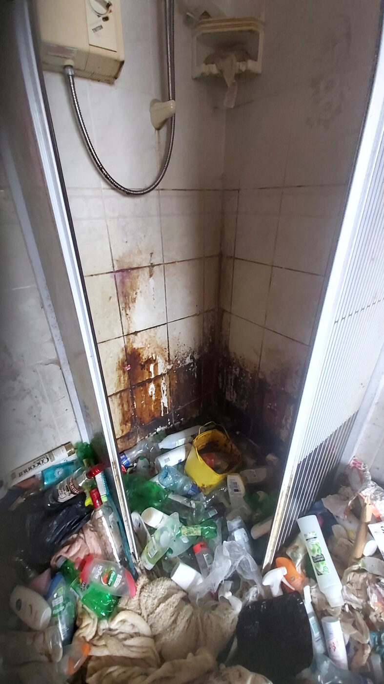 Severely neglected shower area requiring extreme cleaning and waste clearance